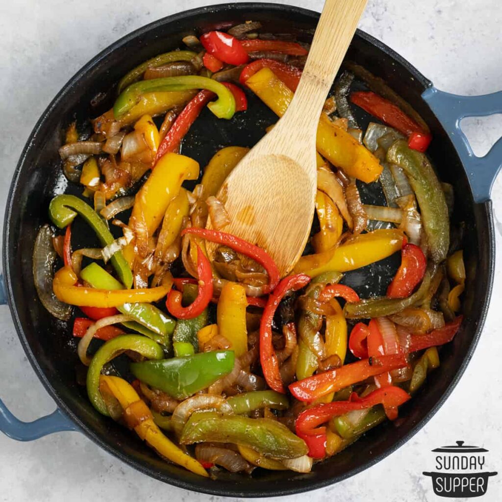 Sautéing the chopped onion, garlic, tomato, and green bell pepper