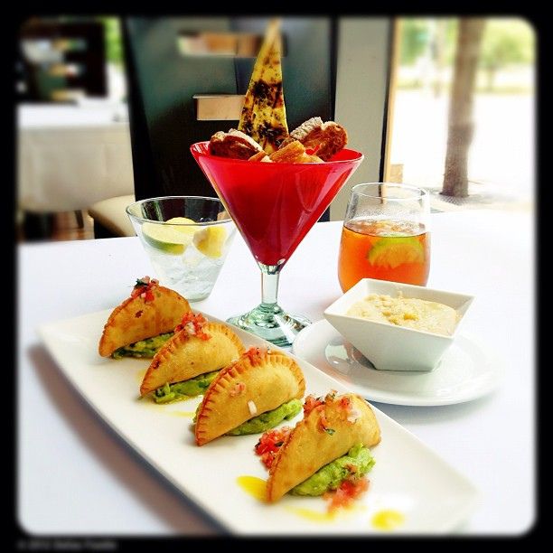 Fine-dining plated empanada with gourmet sauce drizzle and edible flowers.