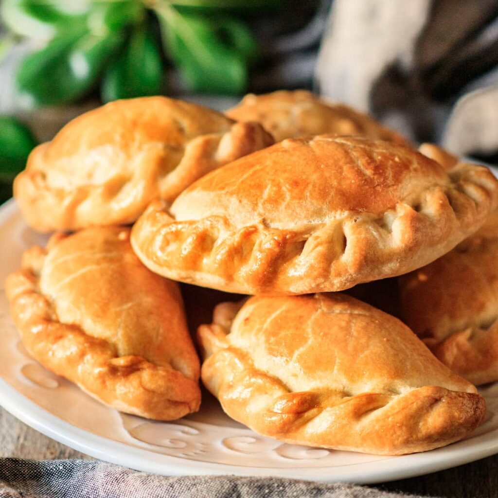 Prepped frozen empanadas organized in a labeled freezer tray.