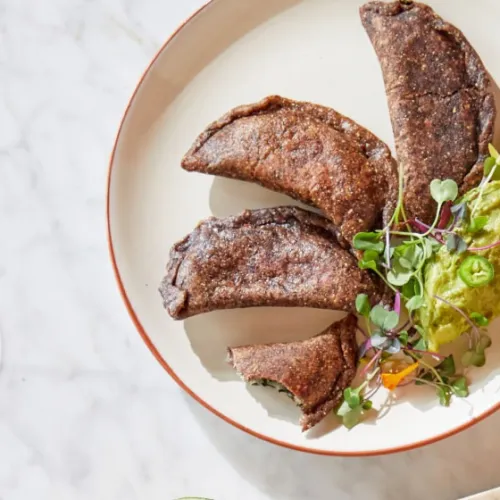 Indigenous-inspired empanadas with heirloom ingredients on a rustic plate.