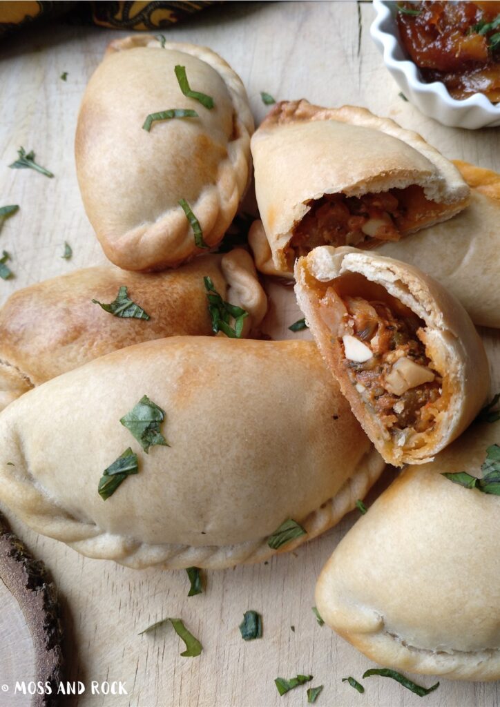  A spicy Thai peanut tofu filling being placed into empanada dough for assembly.
