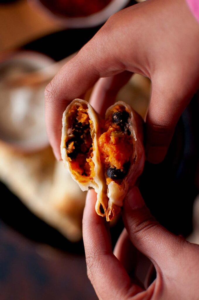  Roasted sweet potato and black bean mixture in a bowl, ready to be used as an empanada filling.